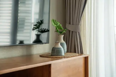 two vases sitting on top of a dresser at Title Halo Andaman Coast Pool View Gym in Nai Yang Beach