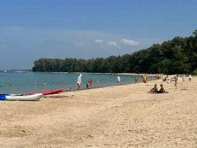 a group of people on a beach near the water at Title Halo Andaman Coast Pool View Gym in Nai Yang Beach