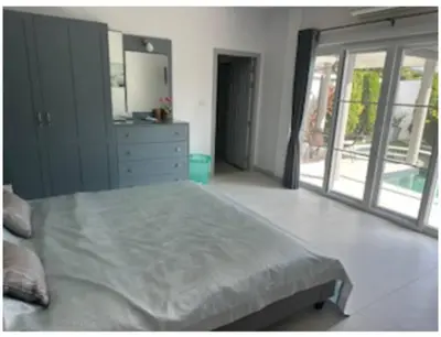 a bedroom with a bed and a dresser and a mirror at Luxury 4 Bedroom Beach House in Ban Saiyuan (1)