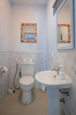 a bathroom with a white toilet and a sink at Luxury 4 Bedroom Beach House in Ban Saiyuan (1)