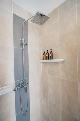 a shower with a shower head in a bathroom at Luxury 4 Bedroom Beach House in Ban Saiyuan (1)