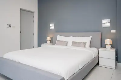 a bedroom with a large white bed with two lamps at Luxury 4 Bedroom Beach House in Ban Saiyuan (1)