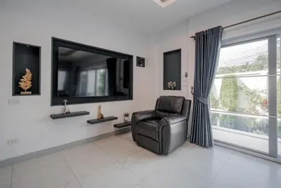 a living room with a chair and a large window at Luxury 4 Bedroom Beach House in Ban Saiyuan (1)