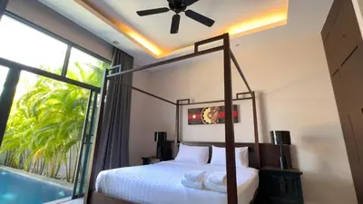 a bedroom with a bed and a large window at Onyx Pool Villa in Phuket Town