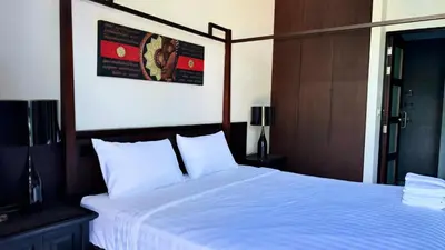 a bedroom with a large bed with white sheets at Onyx Pool Villa in Phuket Town