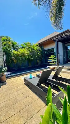 a patio with two chairs and a building at Onyx Pool Villa in Phuket Town