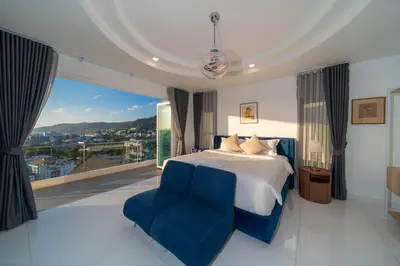 a bedroom with a large bed and a blue chair at \u542b\u65e9\u9910\u9001\u63a5\u673a Phuket patong 4Bedrooms seaview Pool villa in Patong Beach