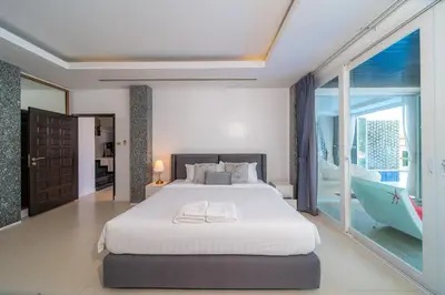 a bedroom with a large bed and a balcony at \u542b\u65e9\u9910\u9001\u63a5\u673a Phuket patong 4Bedrooms seaview Pool villa in Patong Beach