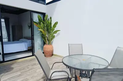 a dining room with a glass table and a plant at Bangtao Beach 600m Laguna 3BDR 3,5bath with Jacuzzi and BBQ up to 8 guests 5 nights Free taxi in Phuket