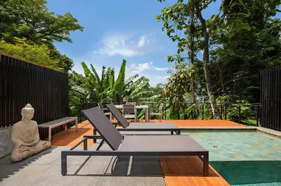 a patio with two lounge chairs and a pool at Stylish 3-Storey Private Pool Villa, Gentle Breeze, Kamala in Kamala Beach