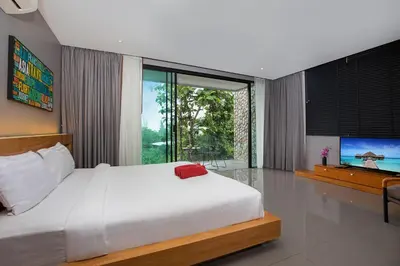 a bedroom with a large bed and a television at Stylish 3-Storey Private Pool Villa, Gentle Breeze, Kamala in Kamala Beach