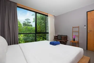 a bedroom with a large bed with a large window at Stylish 3-Storey Private Pool Villa, Gentle Breeze, Kamala in Kamala Beach