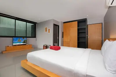 a bedroom with a large white bed and a flat screen tv at Stylish 3-Storey Private Pool Villa, Gentle Breeze, Kamala in Kamala Beach
