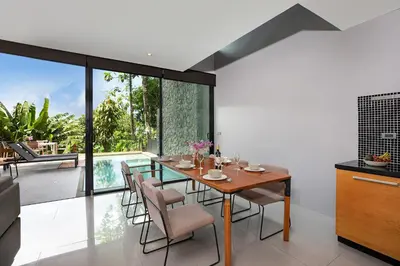 a dining room with a glass table and chairs at Stylish 3-Storey Private Pool Villa, Gentle Breeze, Kamala in Kamala Beach