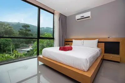 a bedroom with a bed and a large window at Stylish 3-Storey Private Pool Villa, Gentle Breeze, Kamala in Kamala Beach
