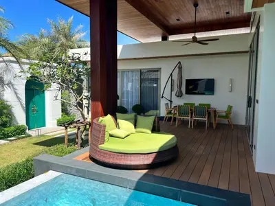a patio with a couch and a table and a pool at Gold Chariot 4BR villa with pool in Phuket