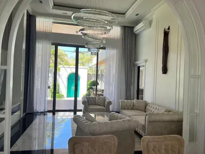 a living room with couches and a table and chairs at Gold Chariot 4BR villa with pool in Phuket