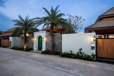 a house with a green door and palm trees at Gold Chariot 4BR villa with pool in Phuket