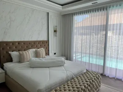 a bedroom with a large bed with a large window at Gold Chariot 4BR villa with pool in Phuket