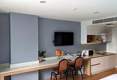 a kitchen with a counter with two chairs and a table at Private apartments near Kata beach in Kata Beach