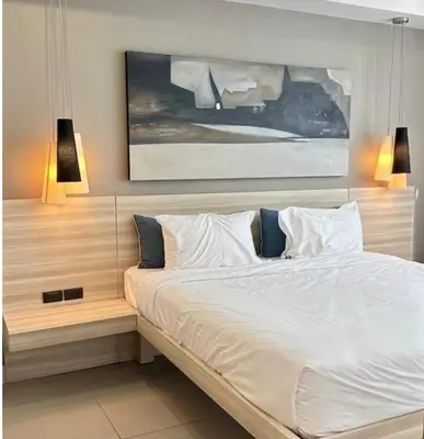 a bedroom with a large white bed with two lights at Oceanstone condo Bangtao Beach in Bang Tao Beach