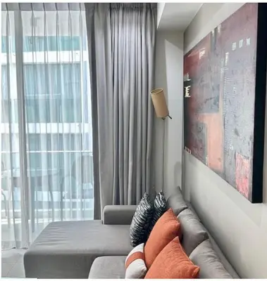 a living room with a couch and a large window at Oceanstone condo Bangtao Beach in Bang Tao Beach