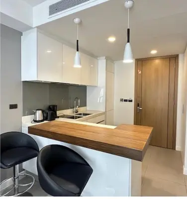 a kitchen with a counter with two black stools at Oceanstone condo Bangtao Beach in Bang Tao Beach