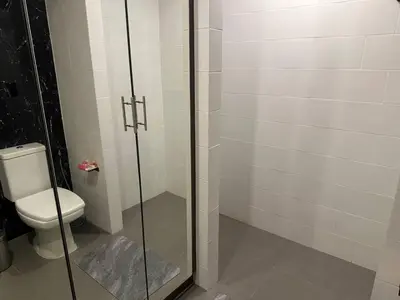 a bathroom with a toilet and a glass shower at Modern apartment on Naiharn Beach B404 in Rawai Beach