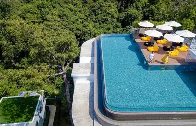 an overhead view of a swimming pool with chairs and umbrellas at Modern apartment on Naiharn Beach B404 in Rawai Beach