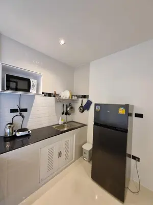 a kitchen with a black refrigerator and a sink at Nua tone riverside resort in Ban Thalat Choeng Thale