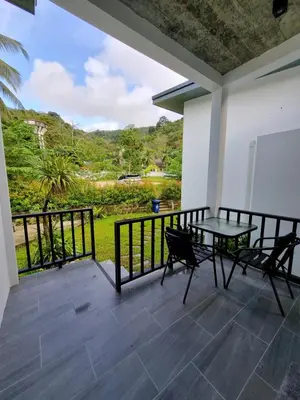 a patio with a table and chairs on a balcony at Nua tone riverside resort in Ban Thalat Choeng Thale