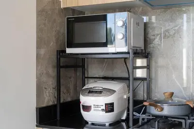 a microwave sitting on top of a stand with a appliance at \u9038\u6d77\u306e\u5922 Laguna\u4e09\u5367\u5ba4\u79c1\u4eba\u6cf3\u6c60\u522b\u5885 in Ban Phru Champa