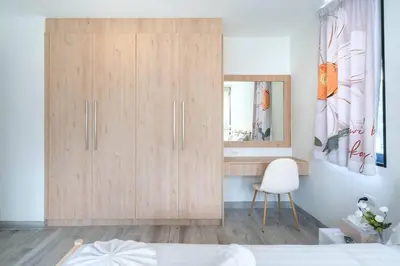 a bedroom with a wooden cabinet and a mirror at \u9038\u6d77\u306e\u5922 Laguna\u4e09\u5367\u5ba4\u79c1\u4eba\u6cf3\u6c60\u522b\u5885 in Ban Phru Champa