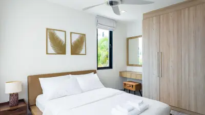 a bedroom with a white bed and a wooden cabinet at Laguna Park 2 Family Pool Villa near Bang Tao Beach in Bang Tao Beach