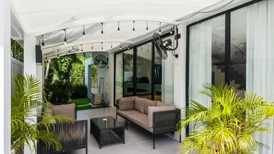 a screened in porch with a couch on a patio at Laguna Park 2 Family Pool Villa near Bang Tao Beach in Bang Tao Beach