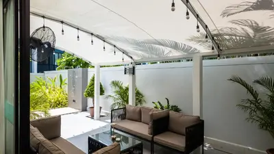 a patio with a couch and a glass table at Laguna Park 2 Family Pool Villa near Bang Tao Beach in Bang Tao Beach