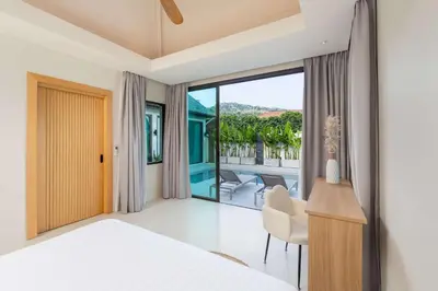 a bedroom with a bed and a desk and a window at Villa Plunge Modern 2-Bedroom with Private Pool in Rawai Beach