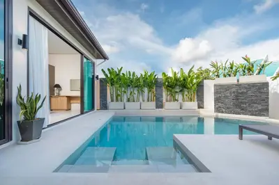 a swimming pool in the backyard of a house at Villa Plunge Modern 2-Bedroom with Private Pool in Rawai Beach