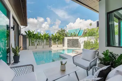 an outdoor patio with a pool and chairs at Villa Plunge Modern 2-Bedroom with Private Pool in Rawai Beach