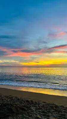a sunset on a beach with the ocean at The Title Halo 1 Naiyang beach in Nai Yang Beach