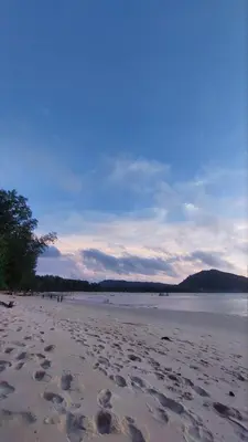 a beach with footprints in the sand and the water at The Title Halo 1 Naiyang beach in Nai Yang Beach