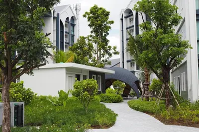 a walkway in front of a building with trees at The Title Halo 1 Naiyang beach in Nai Yang Beach