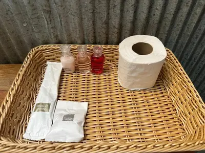 a wicker basket with a roll of toilet paper and drinks at Bangtao Wooden house resort and cafe in Ban Thalat Choeng Thale