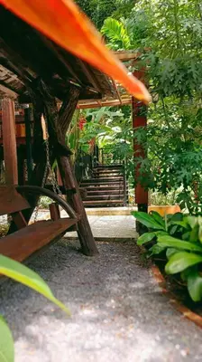 a wooden structure with a staircase in a garden at Bangtao Wooden house resort and cafe in Ban Thalat Choeng Thale