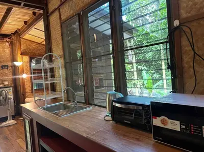 a kitchen with a sink and a large window at Bangtao Wooden house resort and cafe in Ban Thalat Choeng Thale