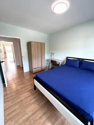 a bedroom with a blue bed and a wooden floor at Villa Patong Beach in Patong Beach