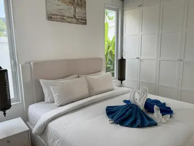 a bedroom with a white bed with two towels on it at Luxury villa Kamala Garden View by Lofty in Kamala Beach