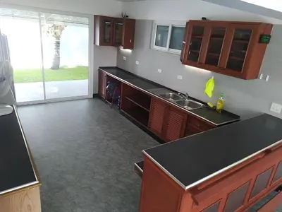 a kitchen with wooden cabinets and a black counter top at 2,5 Zimmerwohnung mit Pool und Pavillon in Rawai Beach