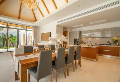 a dining room and kitchen with a table and chairs at Modern 3BR Pool Villa at Anchan Flora in Bangtao in Bang Tao Beach