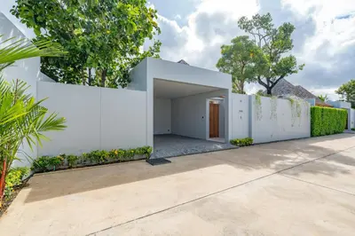 a white house with a white fence and a driveway at Modern 3BR Pool Villa at Anchan Flora in Bangtao in Bang Tao Beach